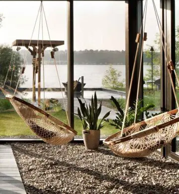 Two Cobble Mountain Summit Hammock Chairs hanging in an outdoor room with a gravel floor and walls of glass