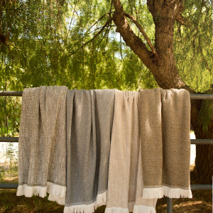Sunbrella indoor outdoor throw blankets draped over a fence rail